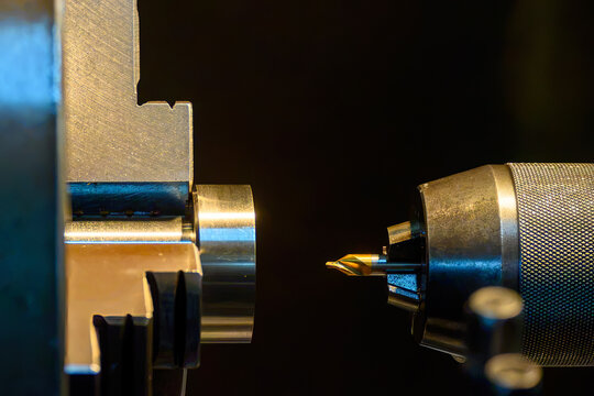 Close-up of a center drill tool with a golden tip for making a pilot hole on a lathe machine