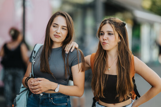 Students and friends talk together outdoors with backpacks, sharing a casual moment of campus life and youth friendship.