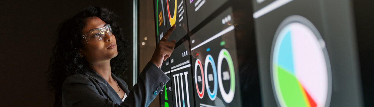 Scientist points to data on a digital display in a lab