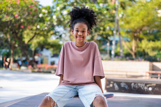 Happy girl sits at a skate park