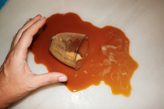 Hand Reaching for Spilled Coffee on Table