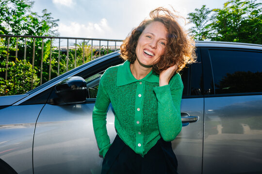 Woman Smiling Beside Car in Sunlight