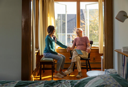 Senior companion Caregiver talking  with elderly man smile