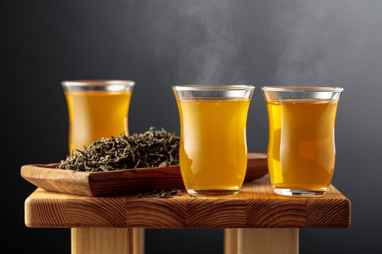 Green tea in small glass cups on an old wooden table.