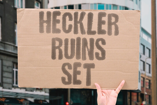 "Heckler ruins set" A loud audience member derails a comic's act with shouted interruptions. HECKLER. RUINS. SET. COMIC. INTERRUPTIONS.