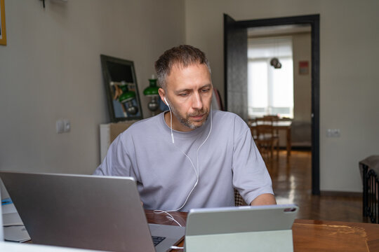 Digital Multitasking at Home, Man Using Laptop and Tablet for Remote Work and Online Learning.