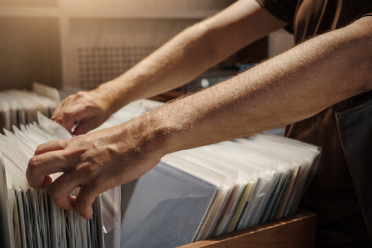 Vinyl Revival and Analog Nostalgia, Hands Browsing Records in Music Store for Physical Media.