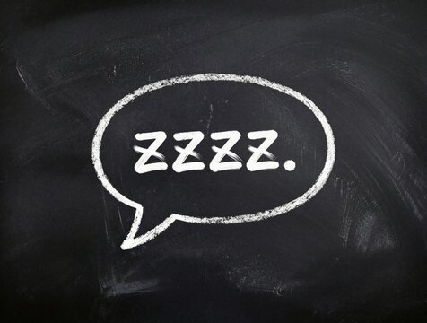 Hand drawn white chalk speech bubble on black chalkboard background. Text ZZZZ. denotes sleep, snoring, tiredness. Minimalist doodle element for comic style pop art, sleeping concept, nap time