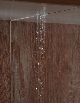Heavy storm rain create water flow from edge of ceiling and dirty stain on wall. Water leaking from top ceiling as droplets and flow in old house