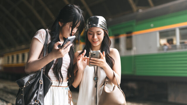 Two young asian woman gen Z content creator arrival at train terminal station friendship local travel trip in Bangkok, Thailand