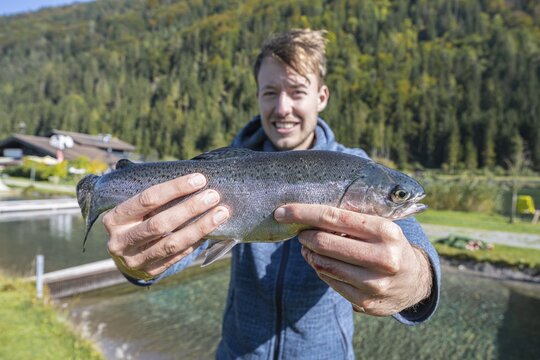 Man holding caught trout, fishing