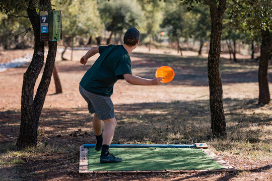 disc golf player throwing forehand from teepad