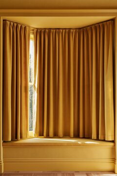 Ochre color drenched living room bay window with floor length wool curtains. Interior design featuring matching walls and textile hero element, color drenching style