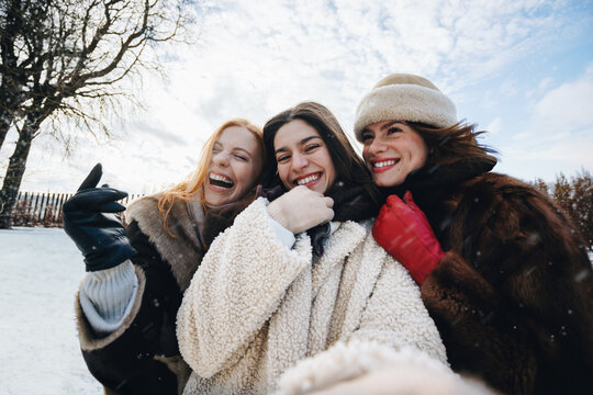 Snowy women share laughter with friends at the winter park