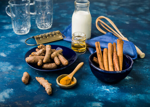 Golden milk ingredients with fresh turmeric and cinnamon sticks