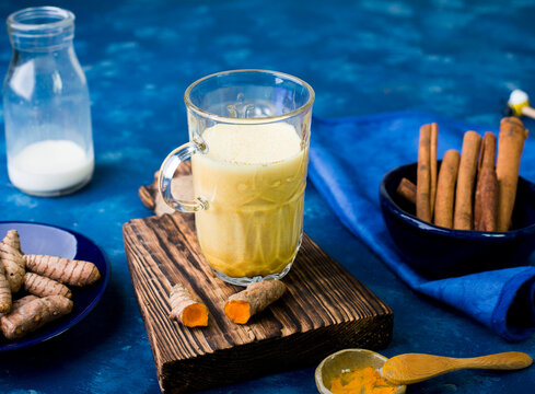 Golden milk with turmeric and cinnamon in glass mug