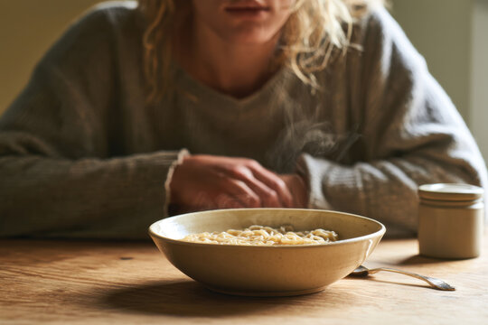 A steaming bowl of noodles set for a cozy meal highlights warmth and comfort in dining, inviting the viewer to experience the essence of home-cooked enjoyment.