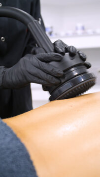 Professional body shaping therapy with vibromassage thermo vacuum and bioelectrical stimulation in beauty salon. 