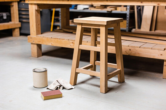 Wooden stool with finishing supplies in a small workshop