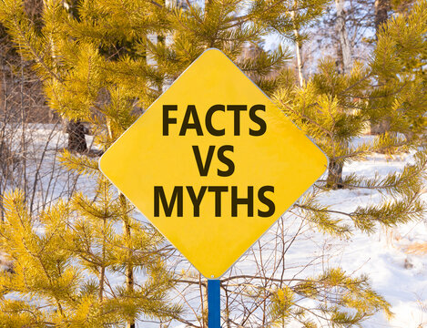 Facts vs versus myths words symbol. Concept words Facts vs Myths on beautiful yellow road sign. Beautiful winter forest background. Business and facts vs versus myths concept. Copy space.