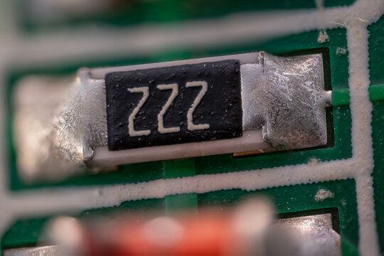 Macro close-up of a resistor soldered onto a printed circuit board.