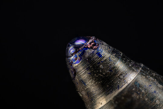 Macro close-up of a ballpoint pen tip with blue ink.