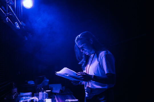 A backstage worker reviews documents closely