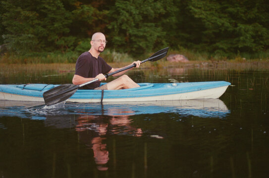 Man kayaking on a lake in Quebec, Mont Tremblant area.